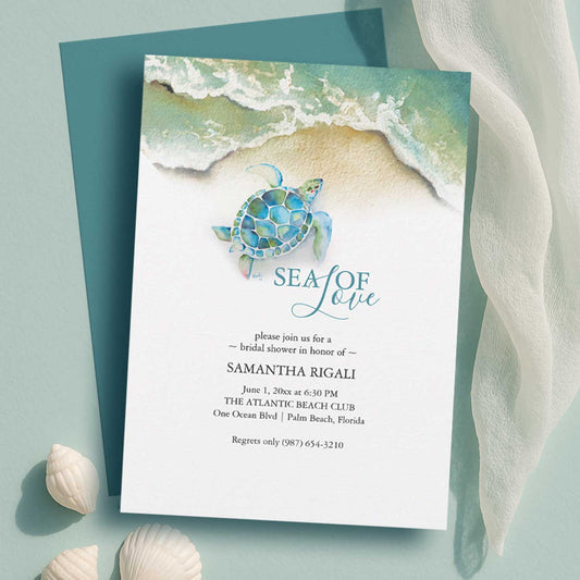 flat lay of a beach bridal shower invitation with watercolor sea turtle and shoreline by Do Tell A Belle a woman owned small business in Palm Beach Gardens, Florida