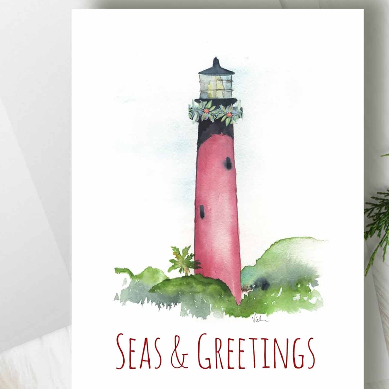 zoomed in flat lay of nautical Christmas cards designed the Jupiter Lighthouse by Florida watercolor artist Victoria Grigaliunas of Do Tell A Belle a woman owned small business in Florida