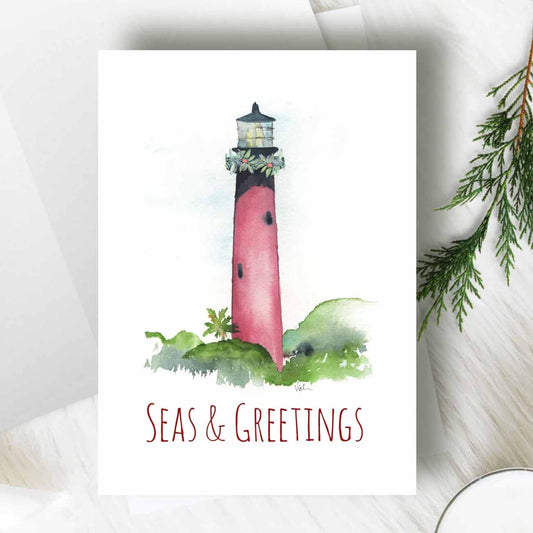 flat lay of nautical Christmas cards designed the Jupiter Lighthouse by Florida watercolor artist Victoria Grigaliunas of Do Tell A Belle a woman owned small business in Florida