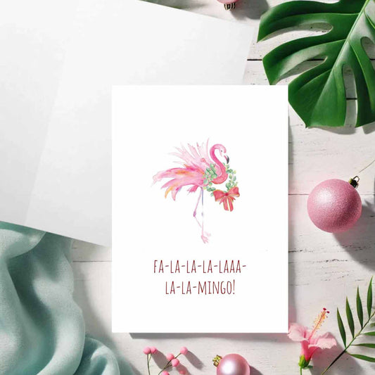 A flat lay of charming pink flamingo Christmas cards designed by watercolor artist Victoria Grigaliunas of Do Tell A Belle a woman owned small business in Palm Beach, Florida