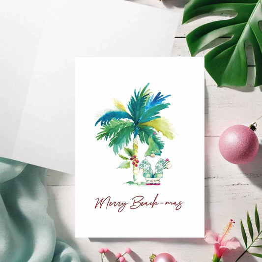 Tropical Christmas cards designed with a palm tree and beach Santa with the words Merry Beach-mas by Florida watercolor artist Victoria Grigaliunas of Do Tell A Belle a woman owned small business
