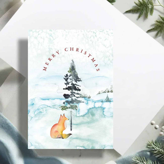 Flat lay of Christmas cards designed with a watercolor fox by Victoria Grigaliunas of Do Tell A Belle a woman owned small busiess.