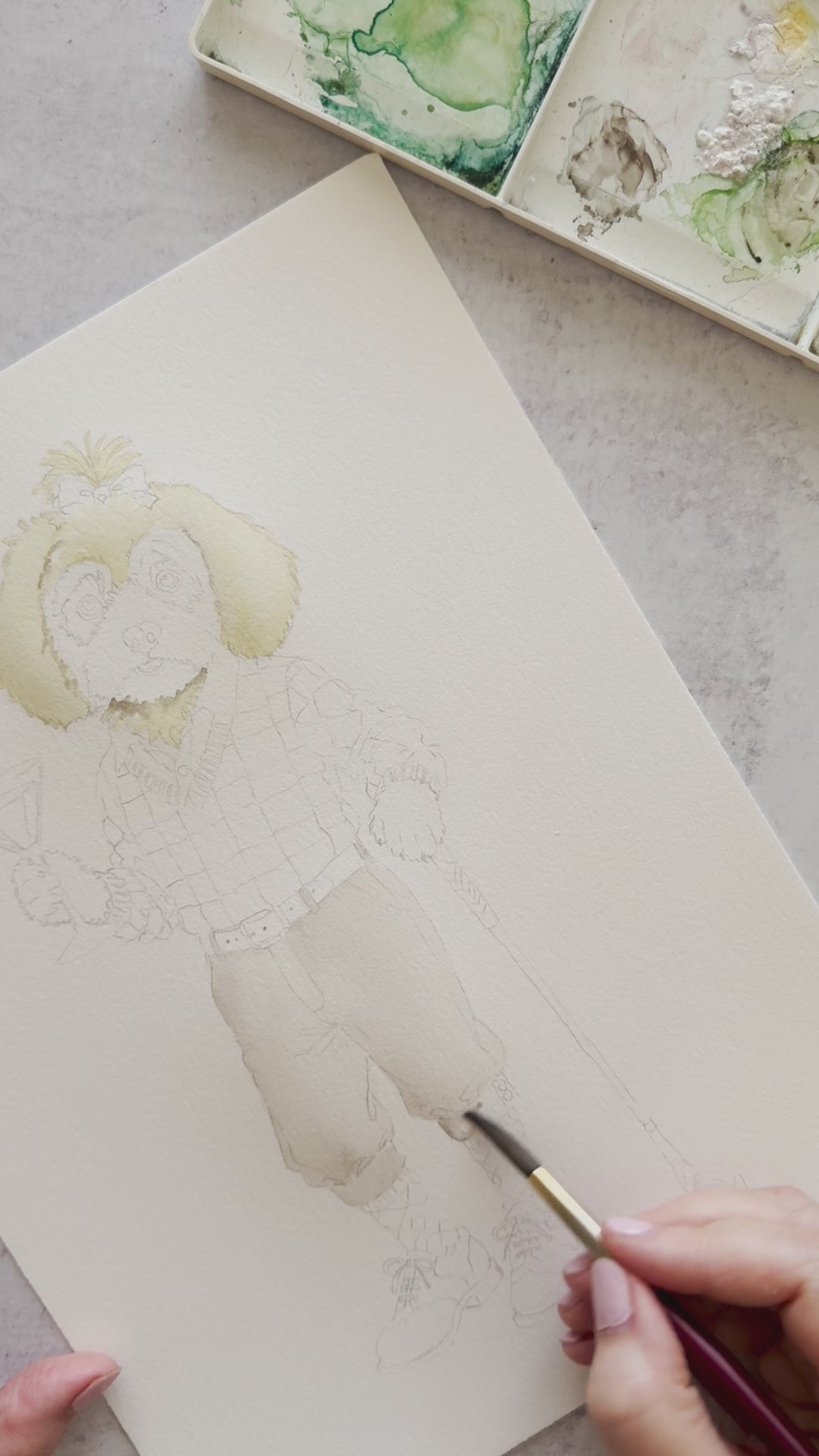 Behind-the-scenes watercolor painting of a Morkie Poo in a Christmas golf outfit holding a peppermint martini for dog Christmas cards.