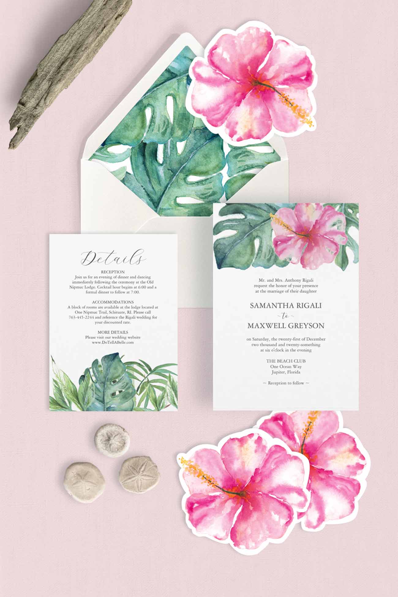 Tropical-themed wedding invitation suite with pink hibiscus flowers and green monstera leaves on a light pink background, styled with driftwood and sand dollars.