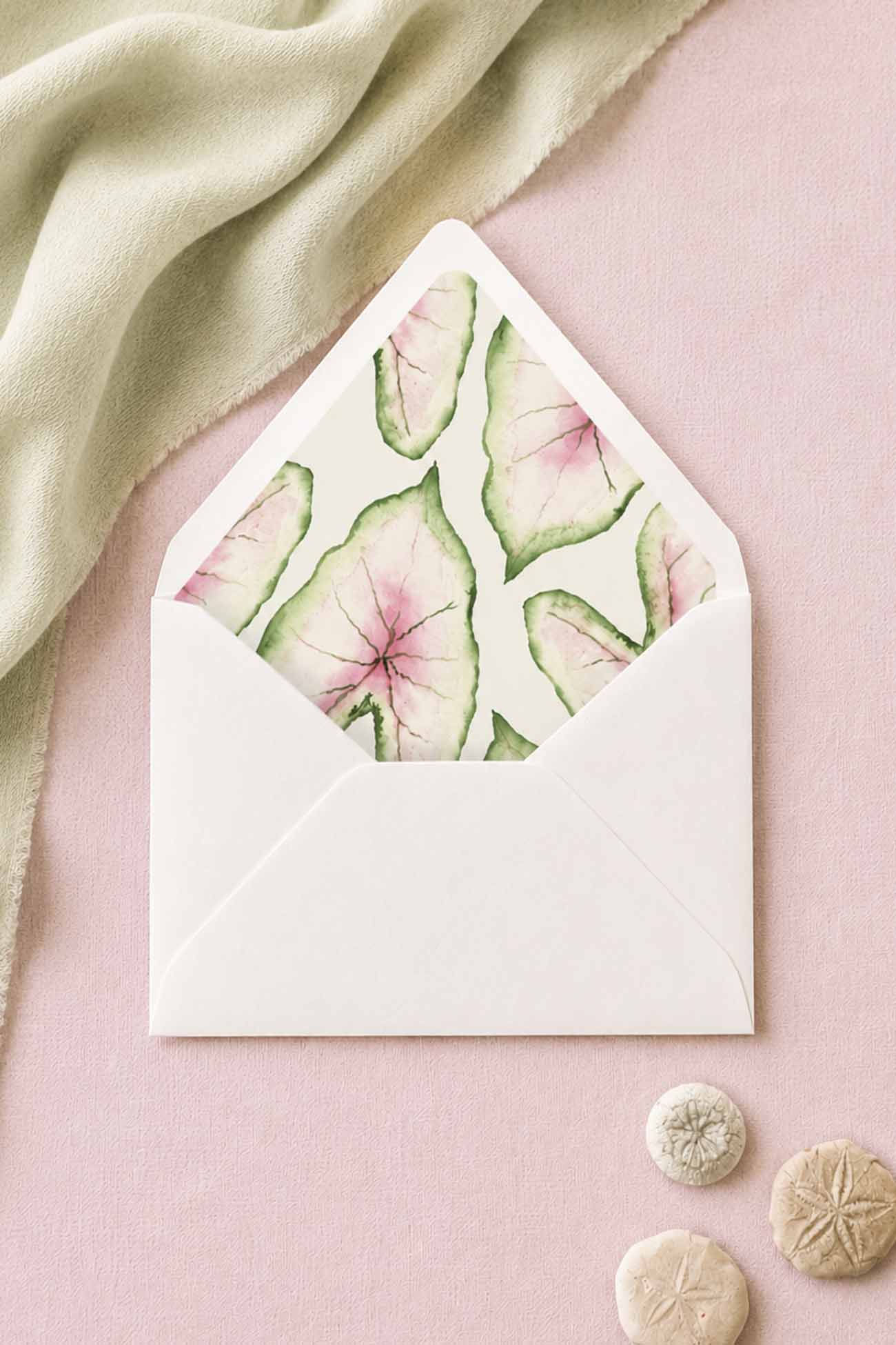 Wedding envelope liners with pointed flap envelopes in shades of pink, green and cream designed with watercolor caladium leaves perfect for a tropical garden wedding.