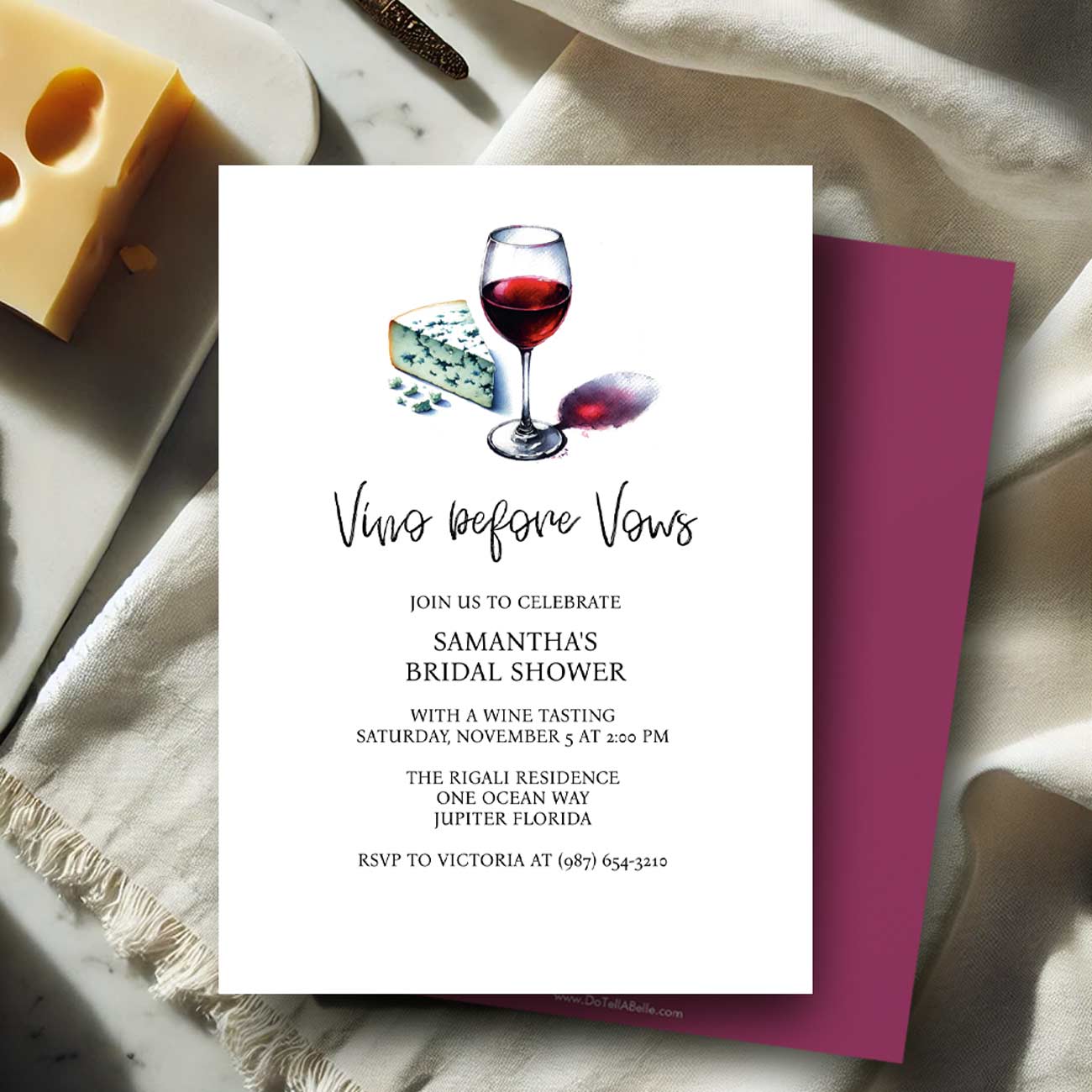 Bridal shower invitation with wine glass and cheese illustration on a marble surface.